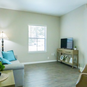 Generous living spaces with beautiful natural lighting a living room with a couch and tv
