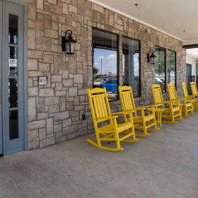 Thoughtful details to elevate your lifestyle a row of yellow rocking chairs near an entrance to a building